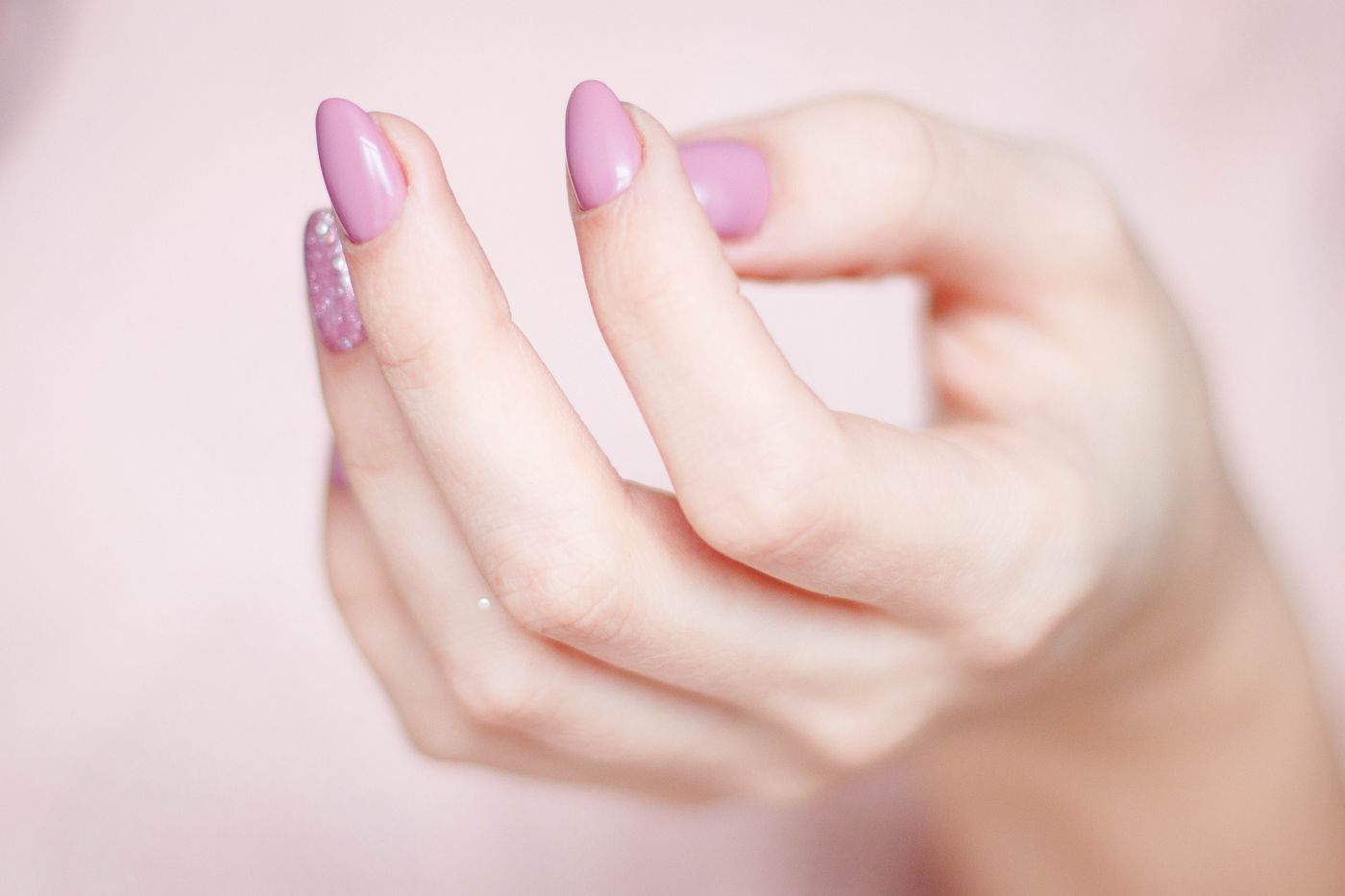 Close-up of a soft pink almond manicure